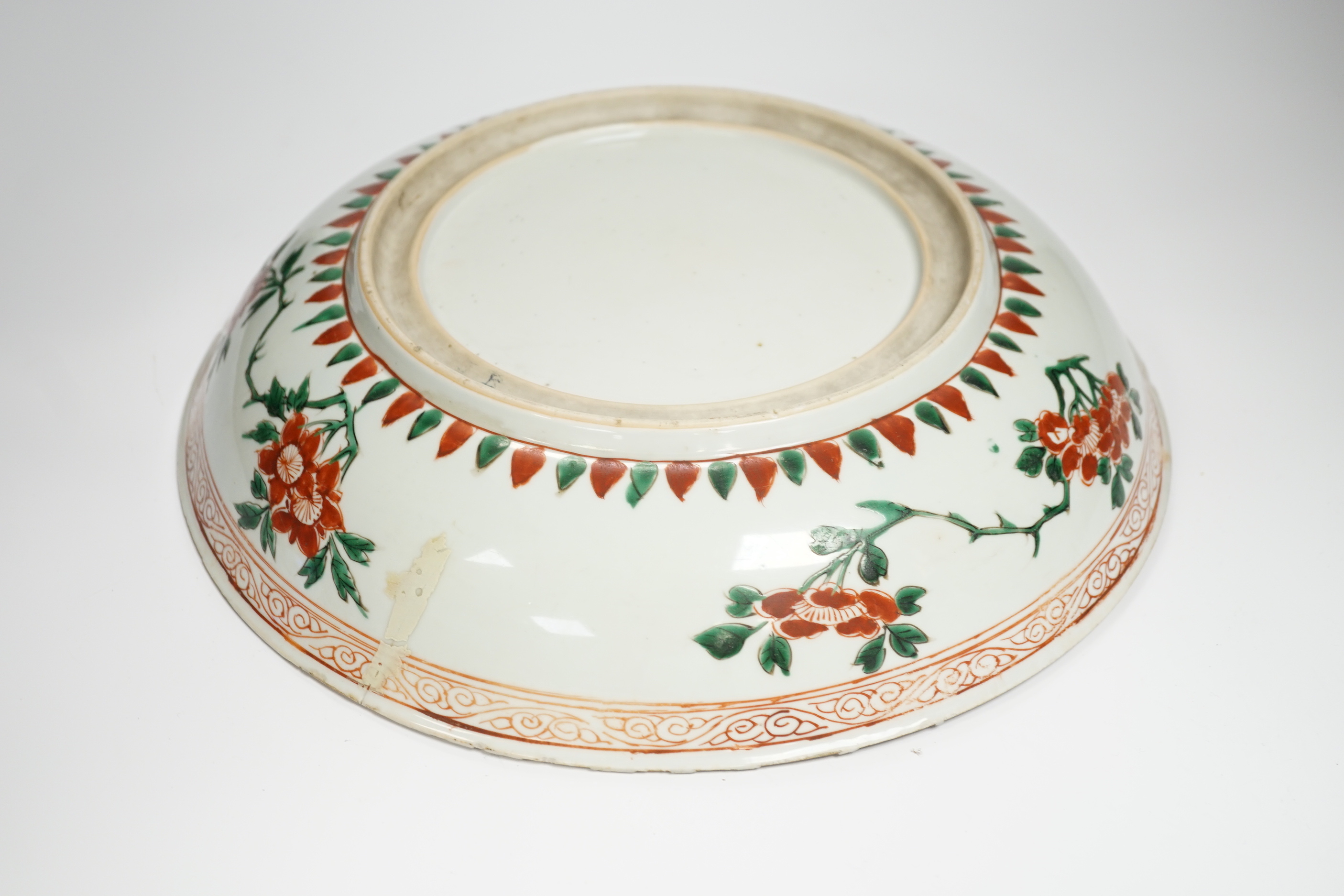 A Chinese famille verte dish, Kangxi period, decorated with flowers bands of brocade patterns, channel moulded foot, 33cm diameter